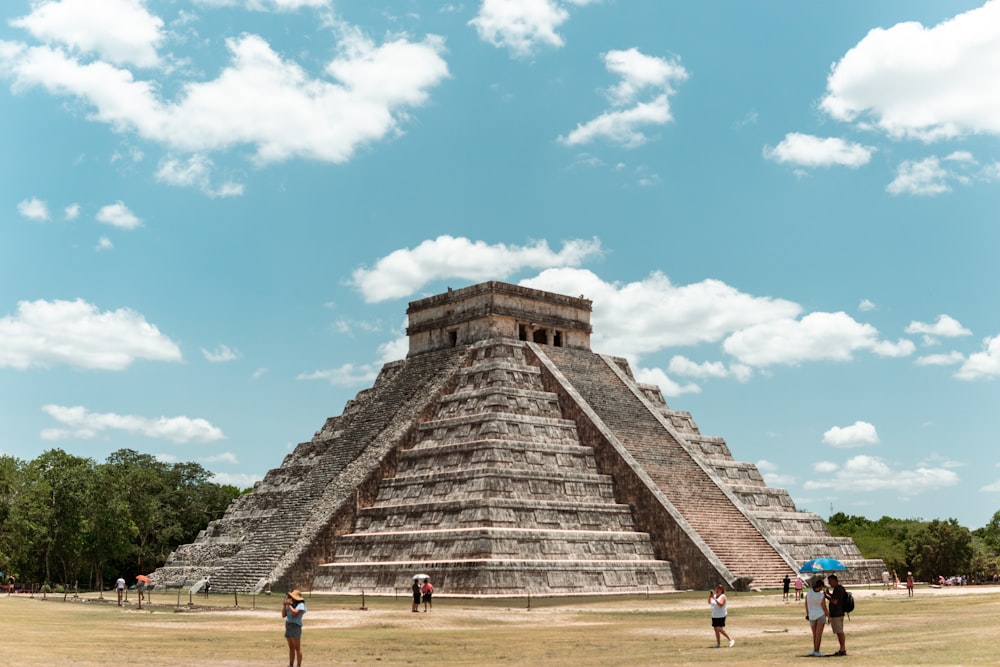 un groupe de personnes debout devant une pyramide