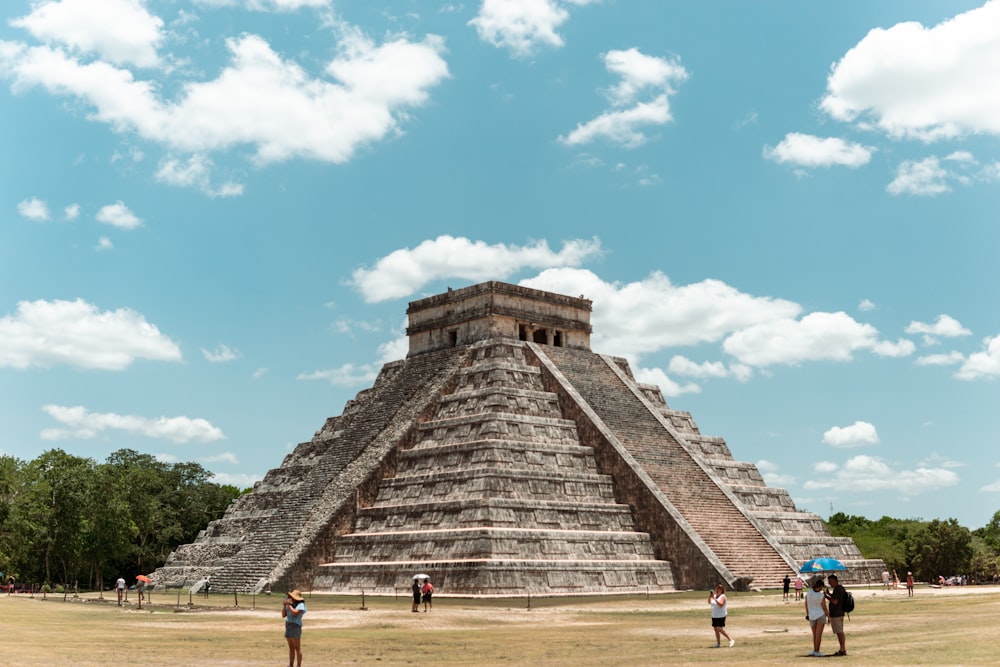 a group of people standing in front of a pyramid