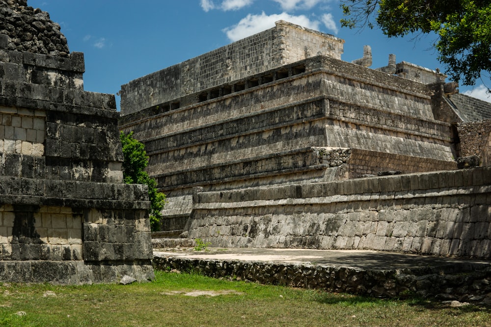 a group of stone structures sitting on top of a lush green field