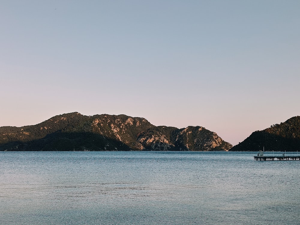 a large body of water with mountains in the background