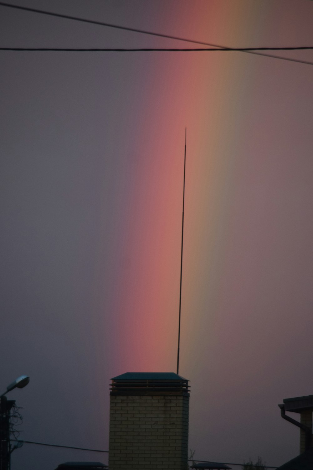 a rainbow shines in the sky over a building