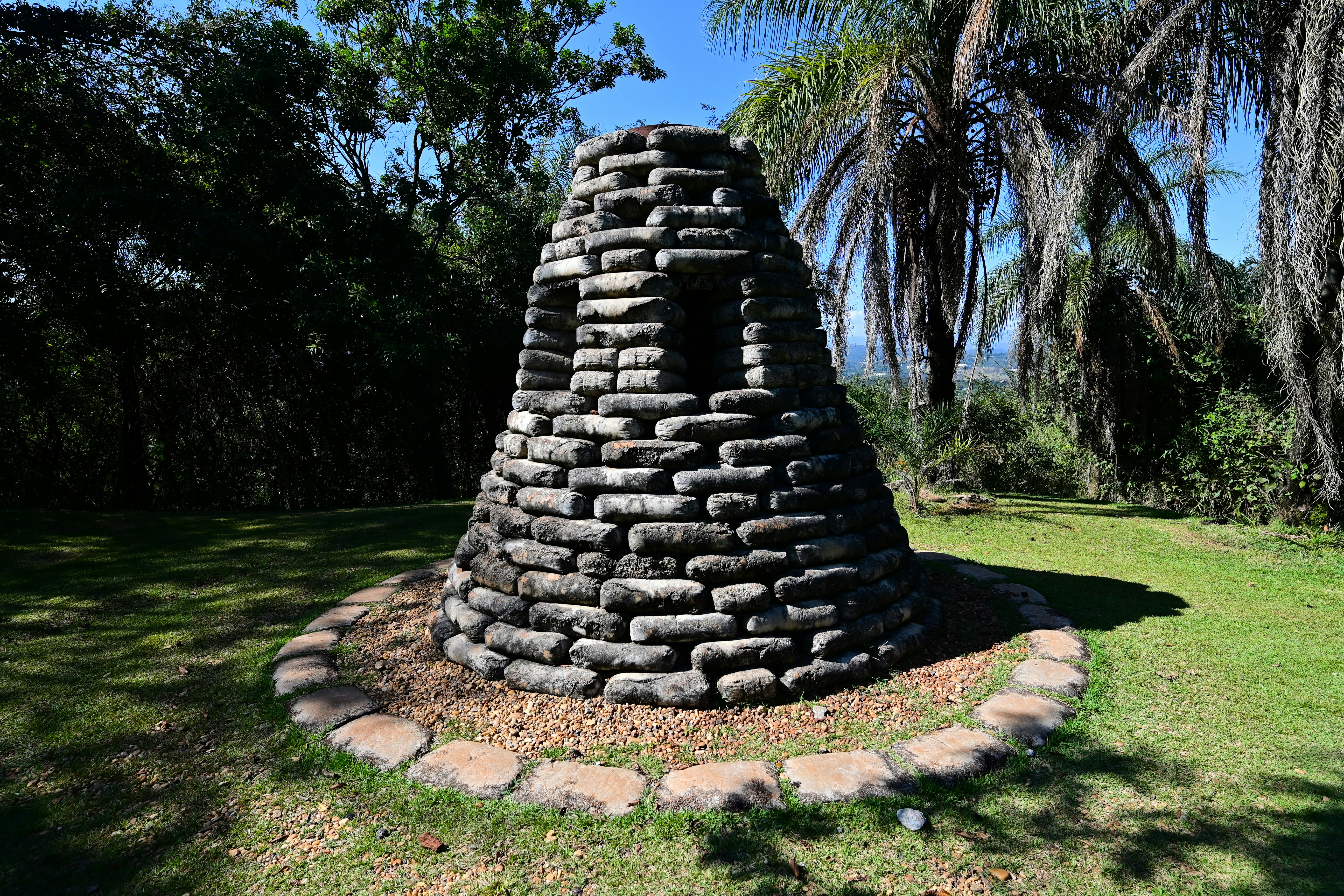 a stone tower in the middle of a grassy area