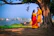 A smiling couple standing by the Ganges River at sunrise, with ancient temples in the background.