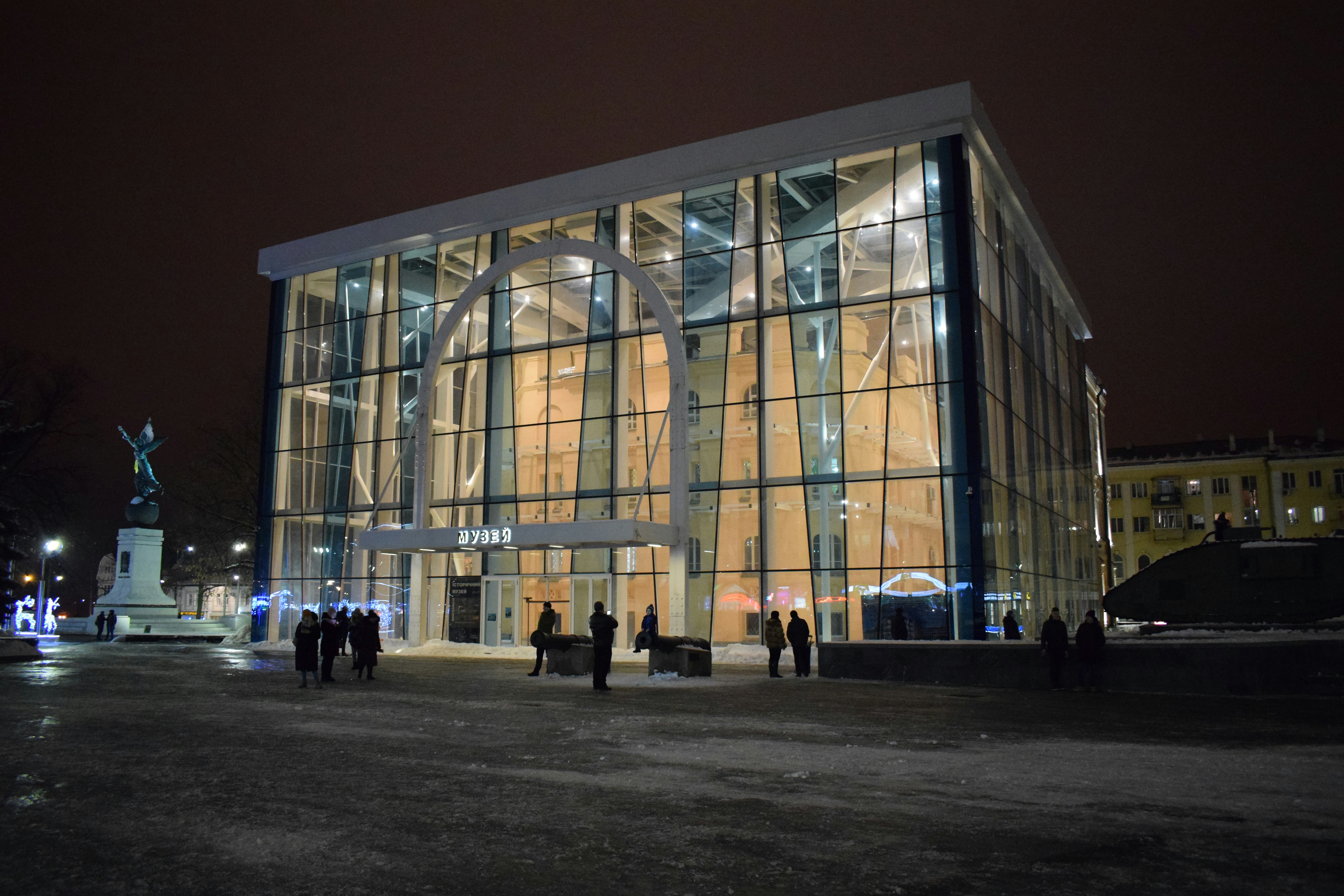 a group of people standing outside of a building at night