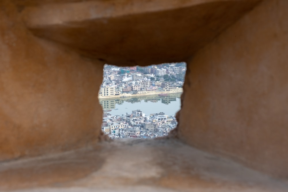 a view of a city through a hole in a rock