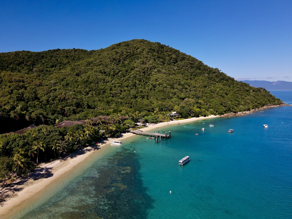 an aerial view of a tropical island with boats