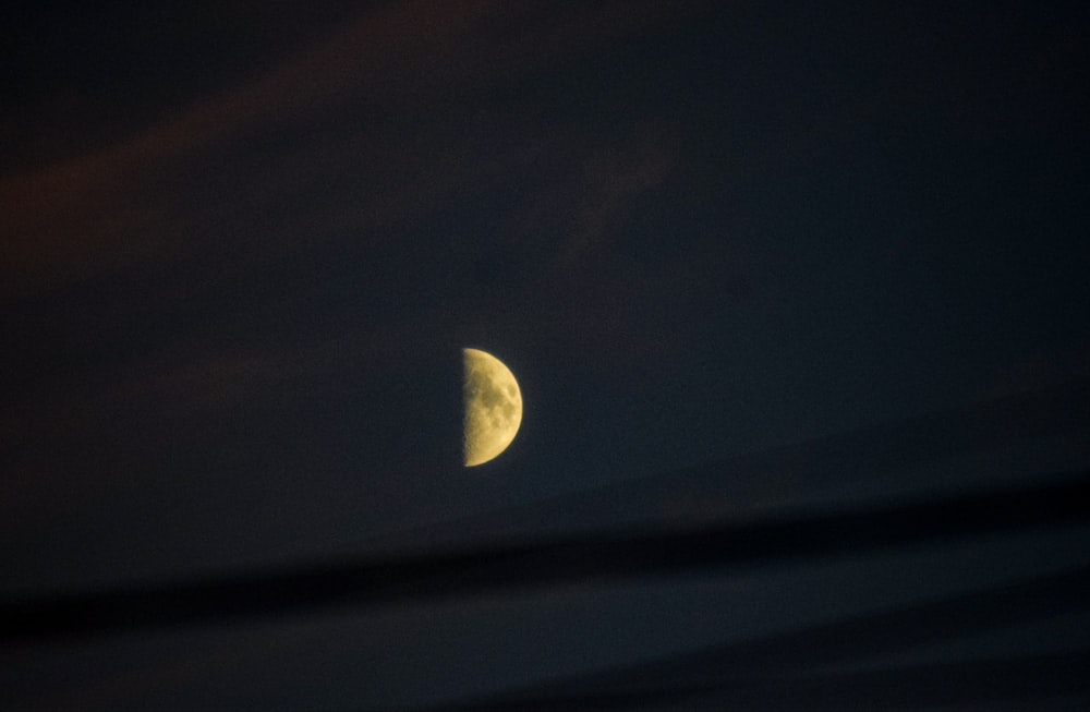 a half moon is seen through the clouds