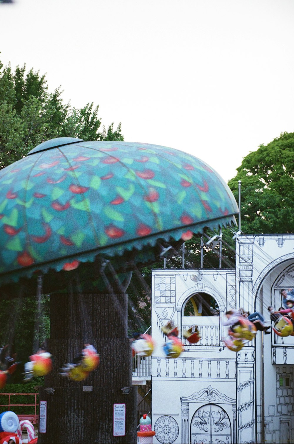 a carnival ride with a large green umbrella