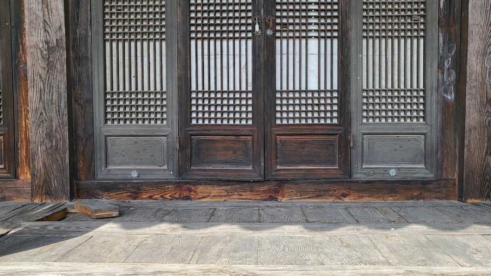 a cat sitting on a wooden floor in front of a wooden door