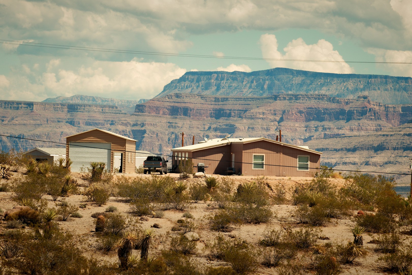 A house in the middle of a desert with mountains in the background representing Buckeye Arizona