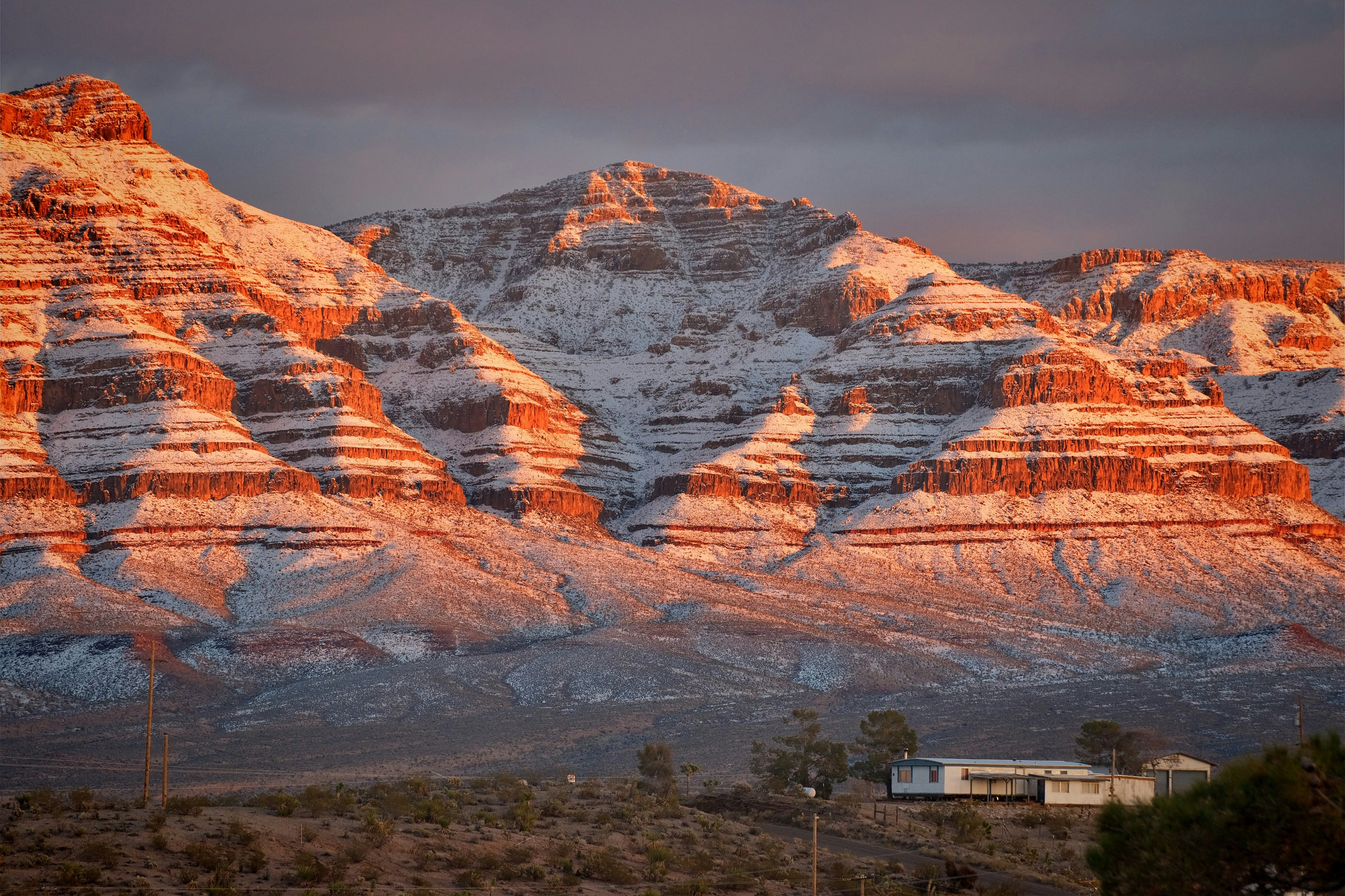 a snow covered mountain with a house in the foreground