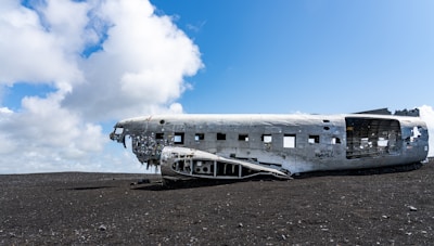 an old airplane sitting on top of a dirt field
