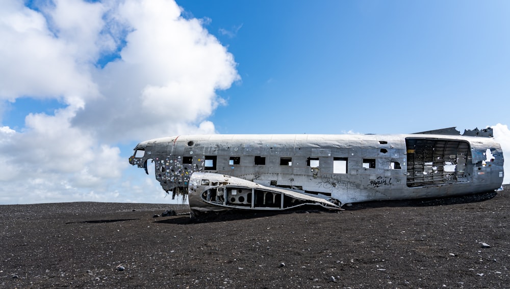 an old airplane sitting on top of a dirt field