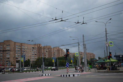 Technicians installing traffic signals and street lighting along a busy city street.