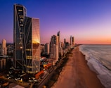 a view of a beach and a city at sunset