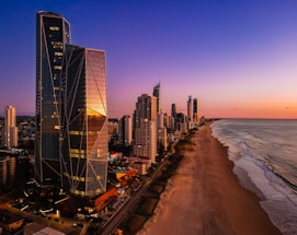 a view of a beach and a city at sunset