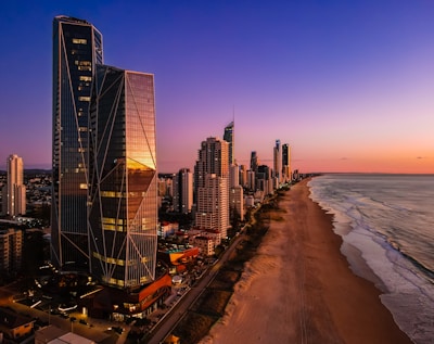 a view of a beach and a city at sunset