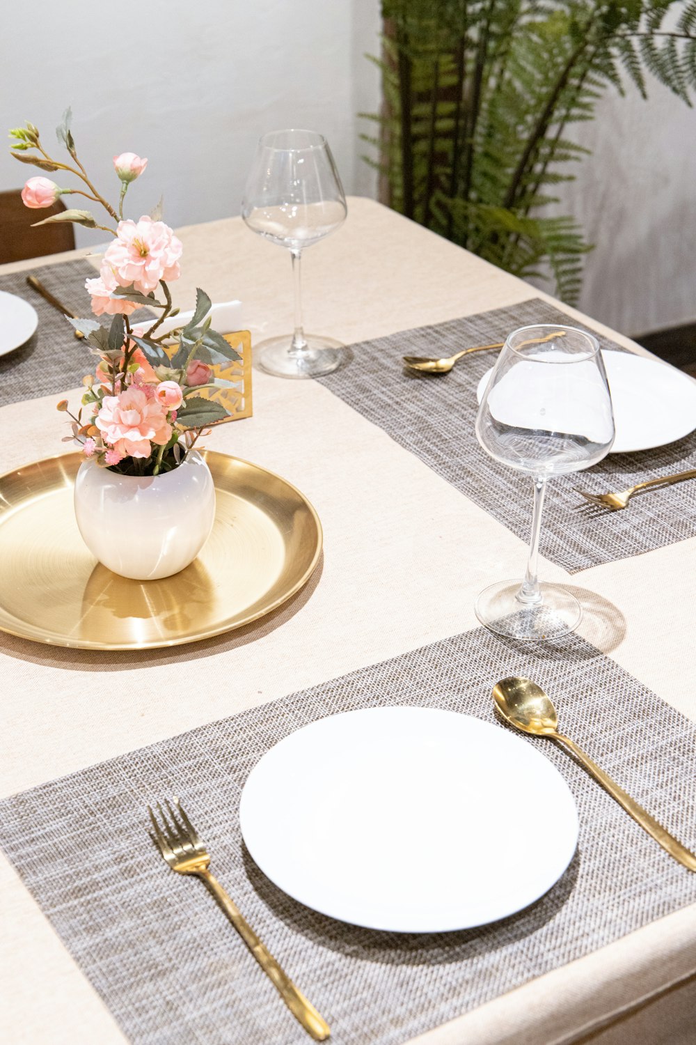 a table set with place settings and a vase of flowers