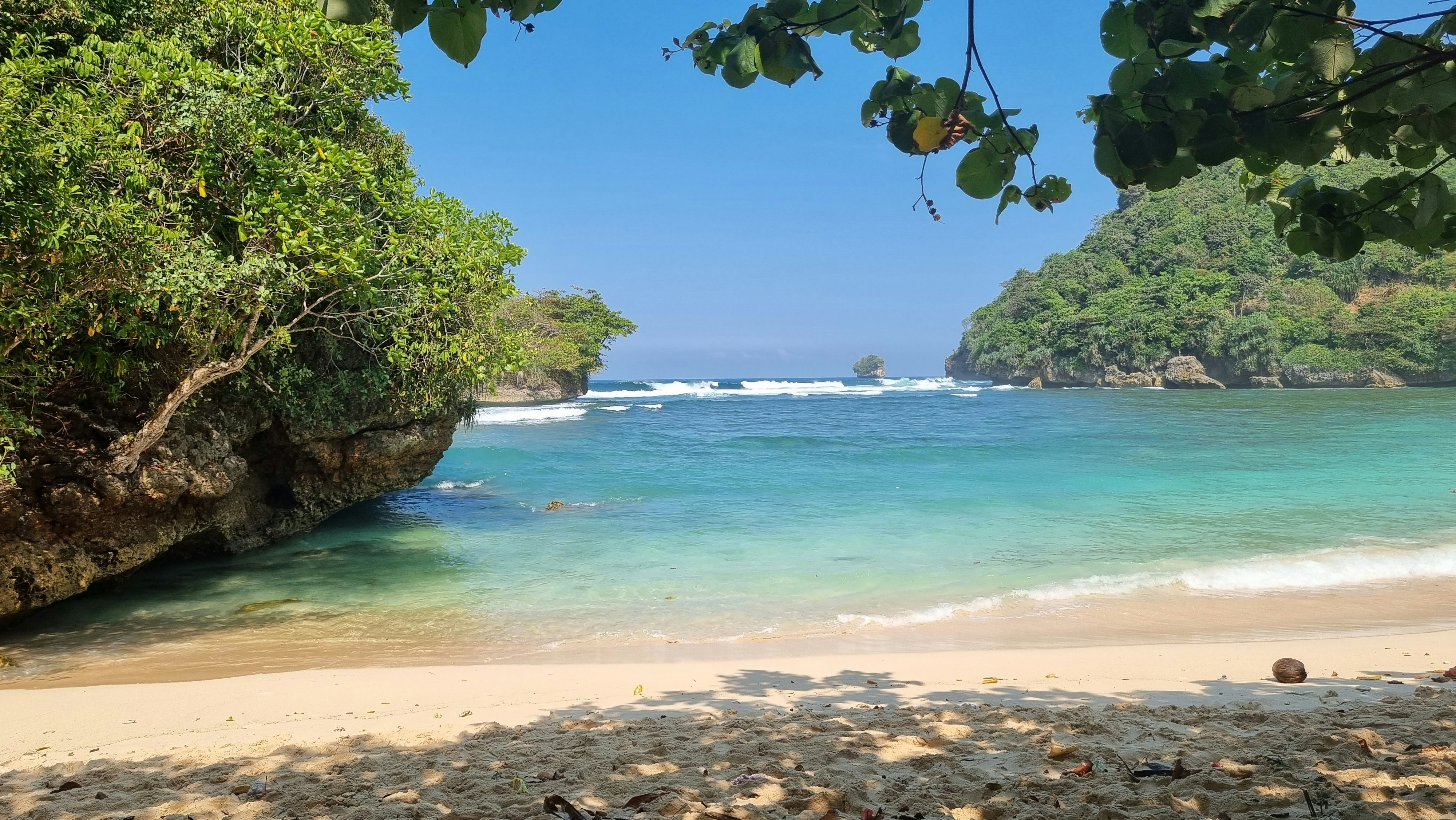 Half Moon Beach — secluded pristine beach with crystal clear water, rocky outcrops, lush tropical vegetation