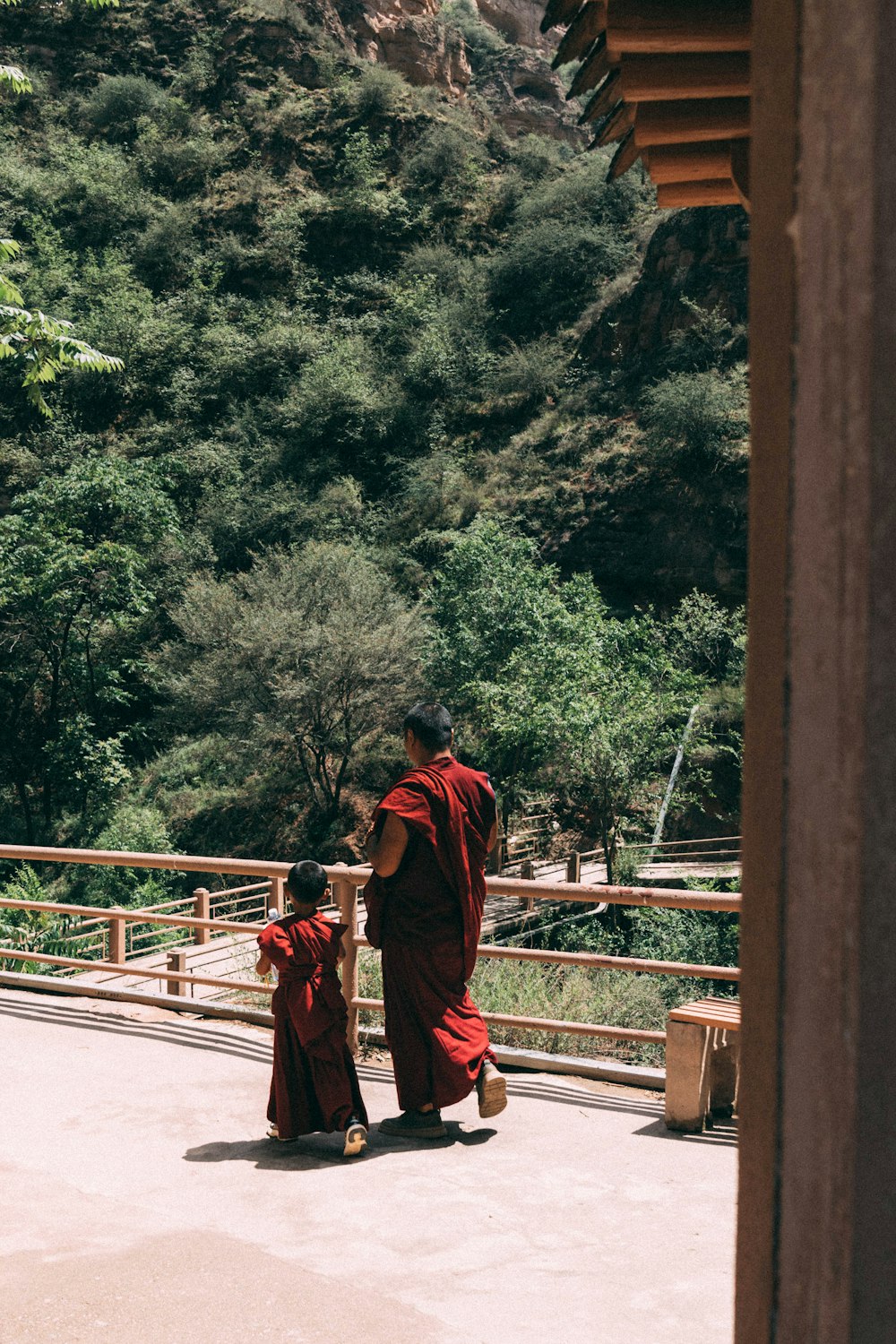 a man in a red robe walking with a child