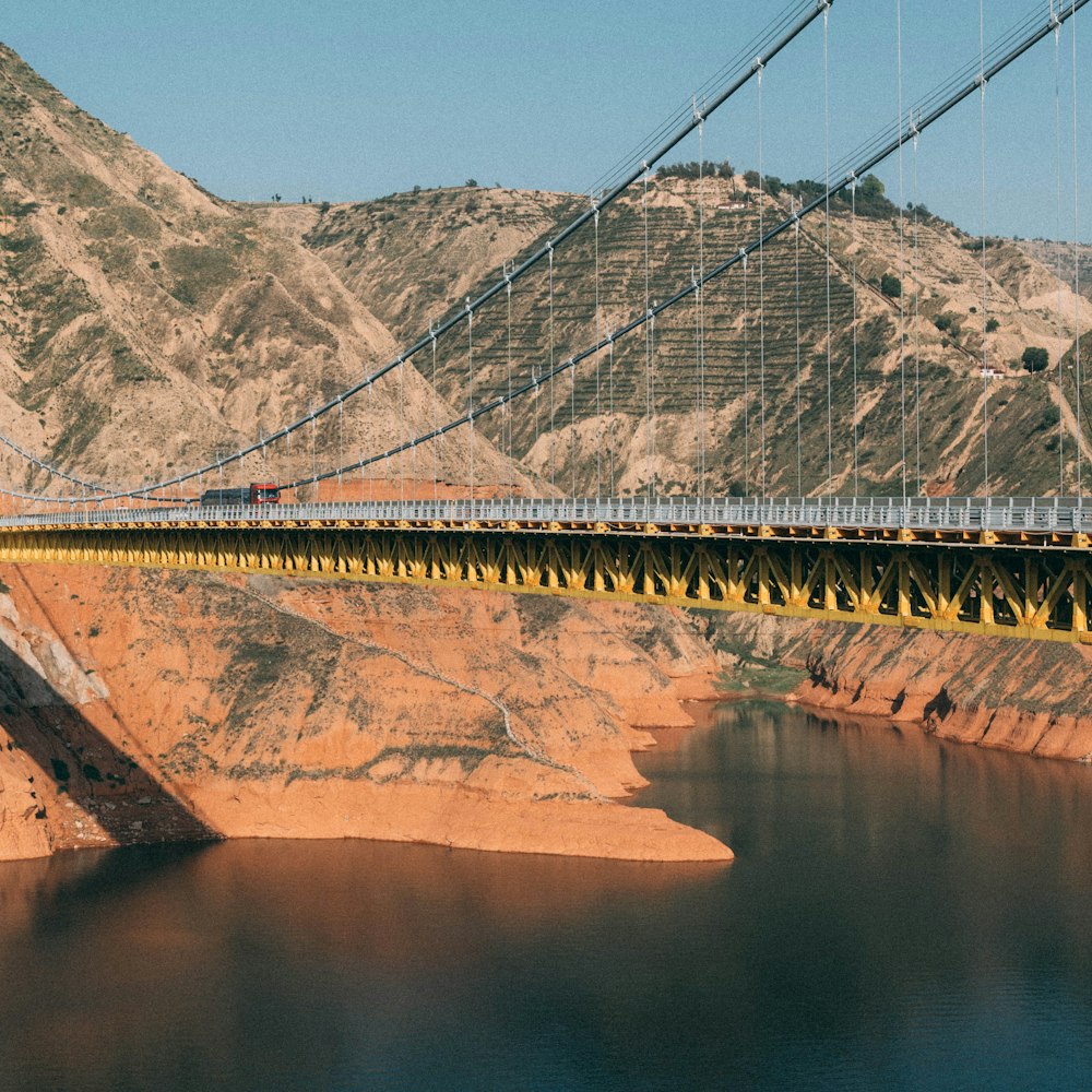 eine Brücke über ein Gewässer mit Bergen im Hintergrund