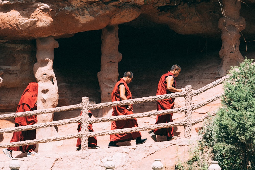a group of monks walking across a bridge