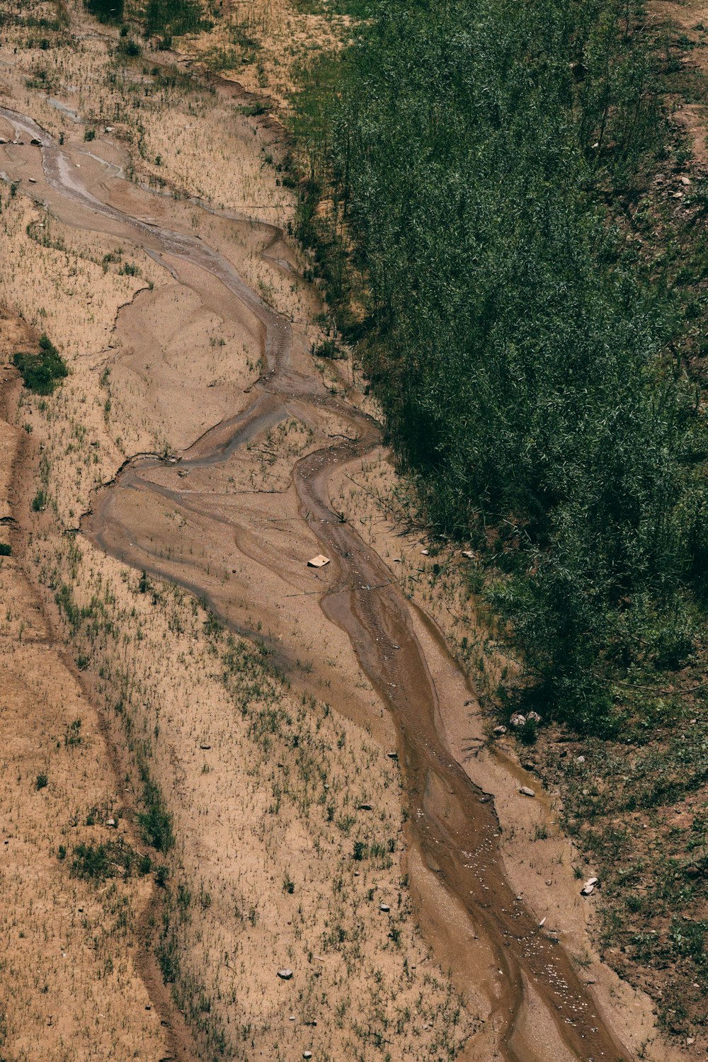 an aerial view of a dirt road in the middle of a field