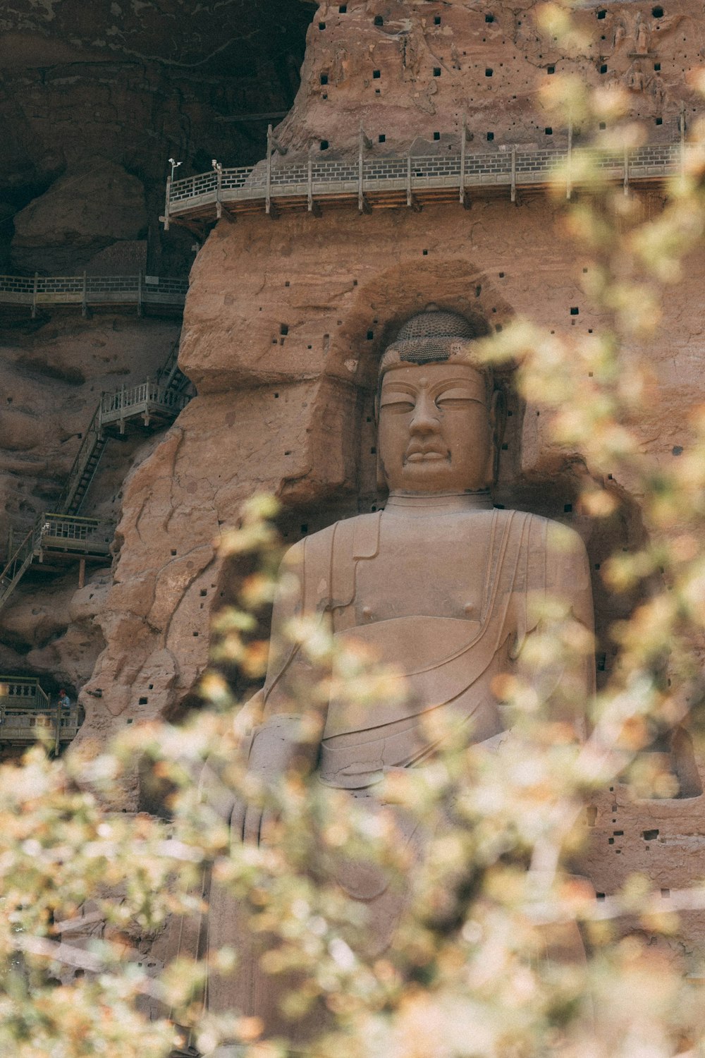 a large buddha statue sitting in front of a mountain