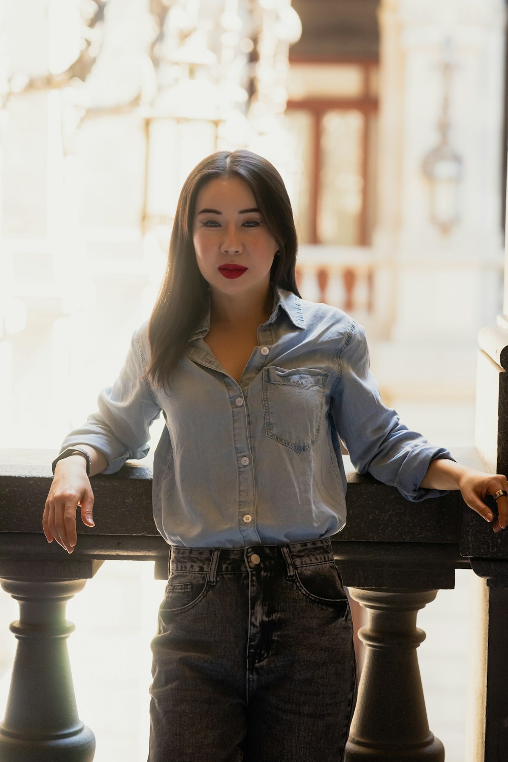 a woman leaning on a railing with her hands on her hips