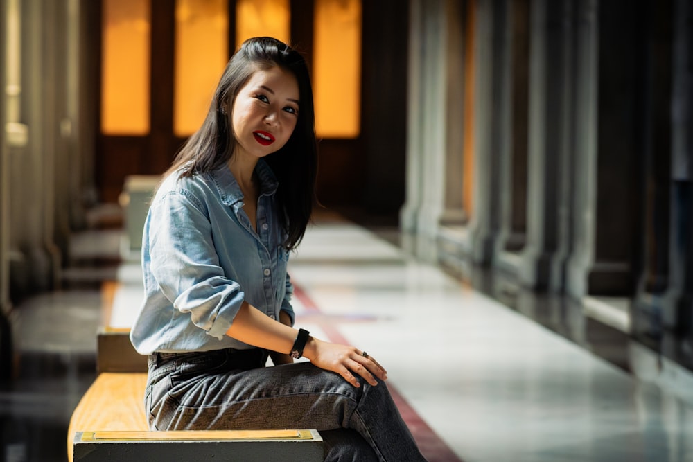 a woman sitting on top of a wooden bench