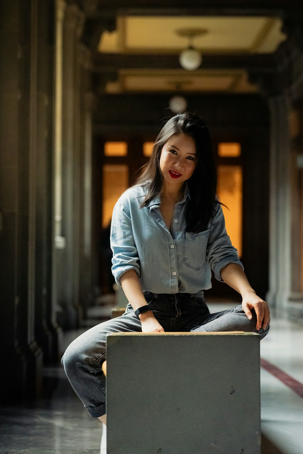 a woman sitting on top of a box in a building