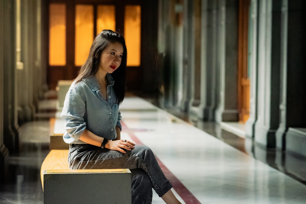 a woman sitting on a bench in a building