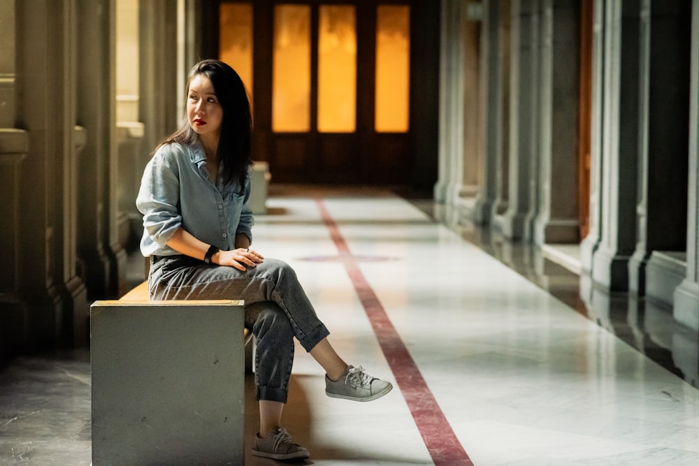 a woman sitting on a bench in a hallway