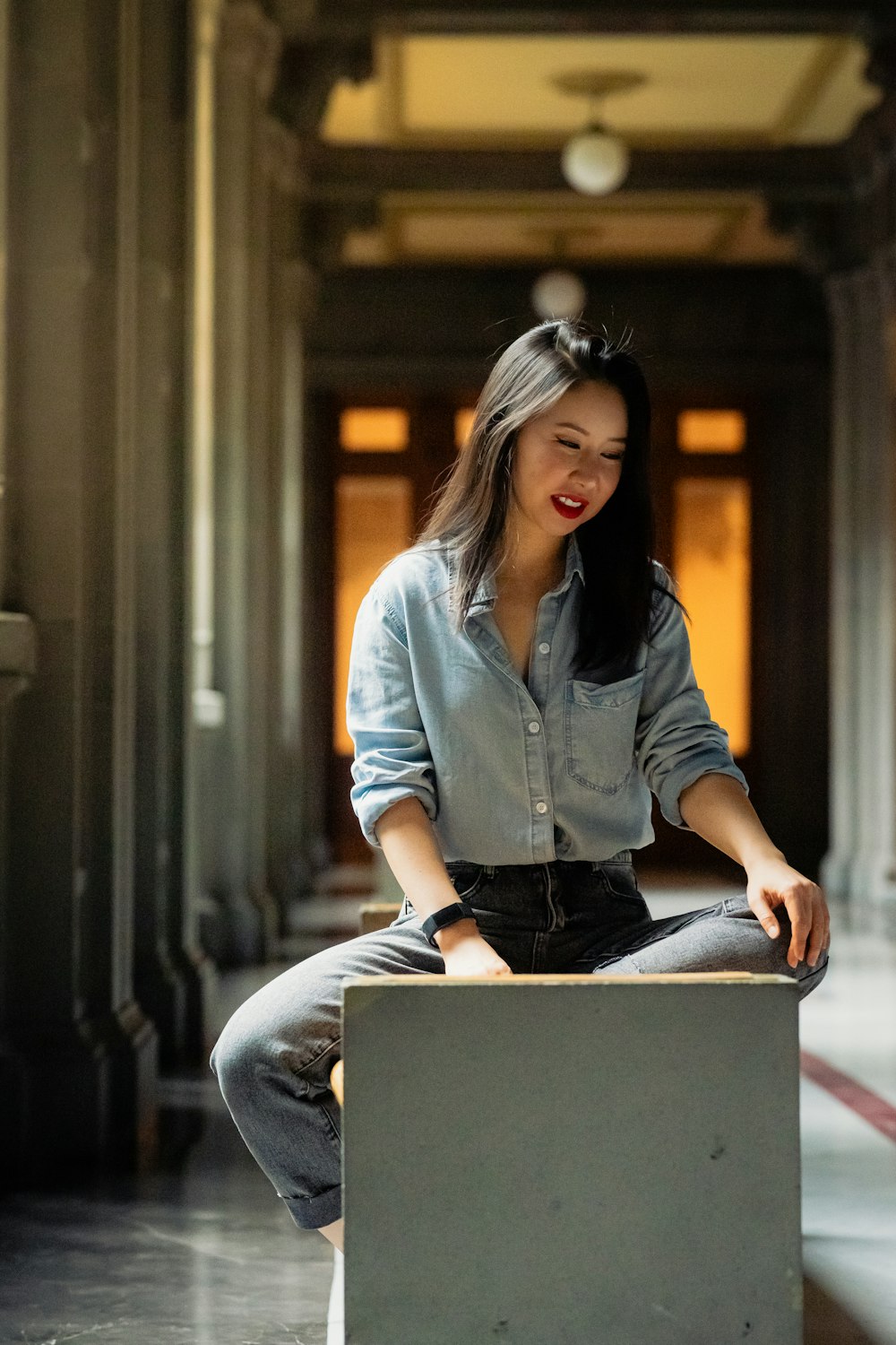 a woman sitting on top of a box in a building