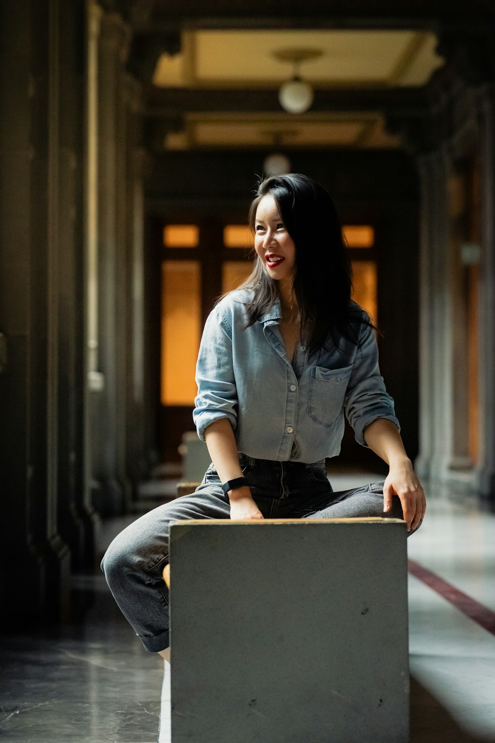 a woman sitting on top of a box in a building