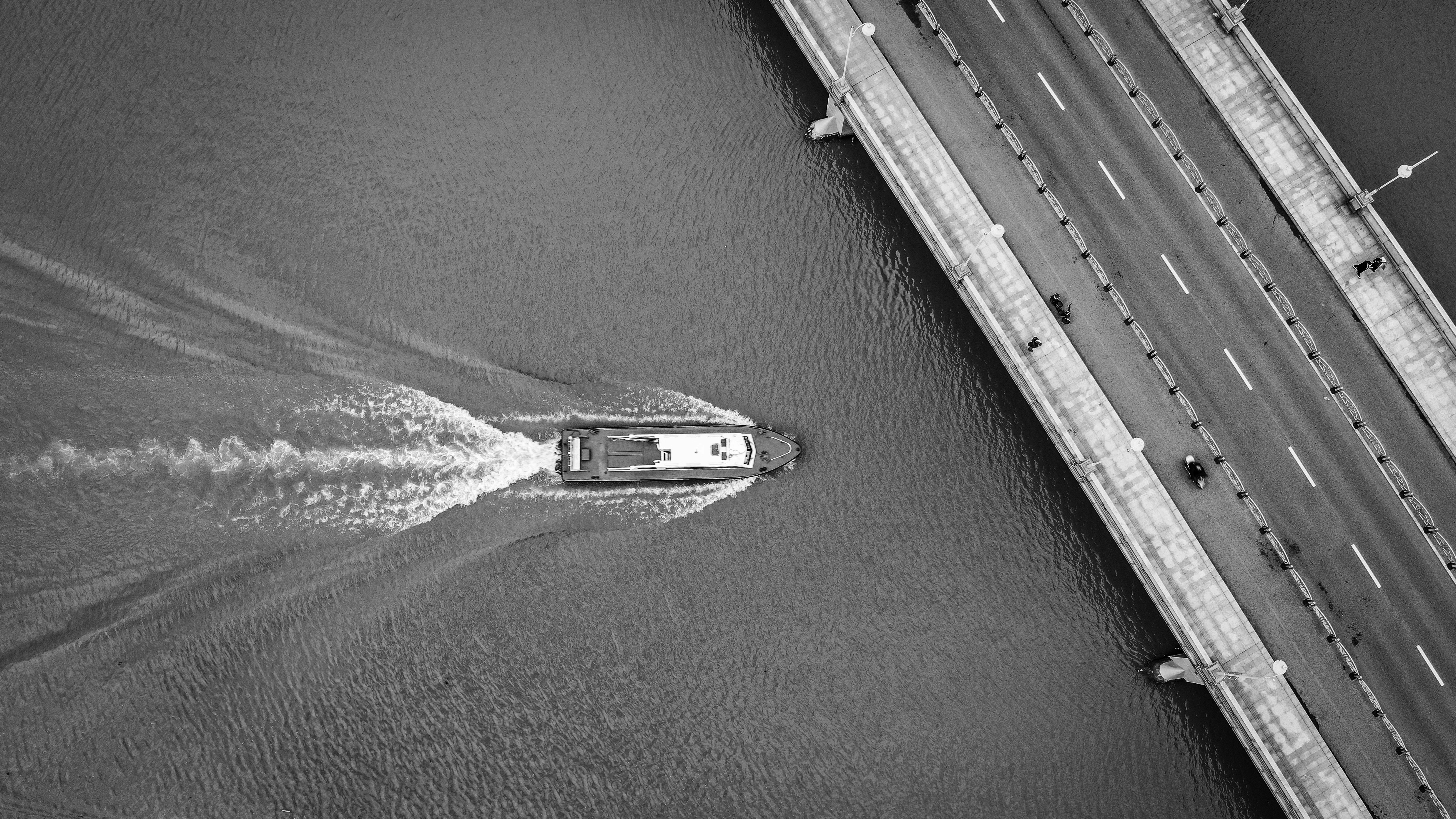 a boat traveling across a river next to a bridge