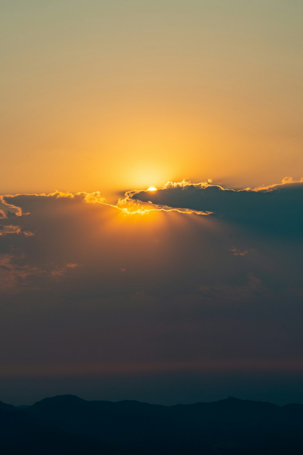 a plane flying in the sky at sunset