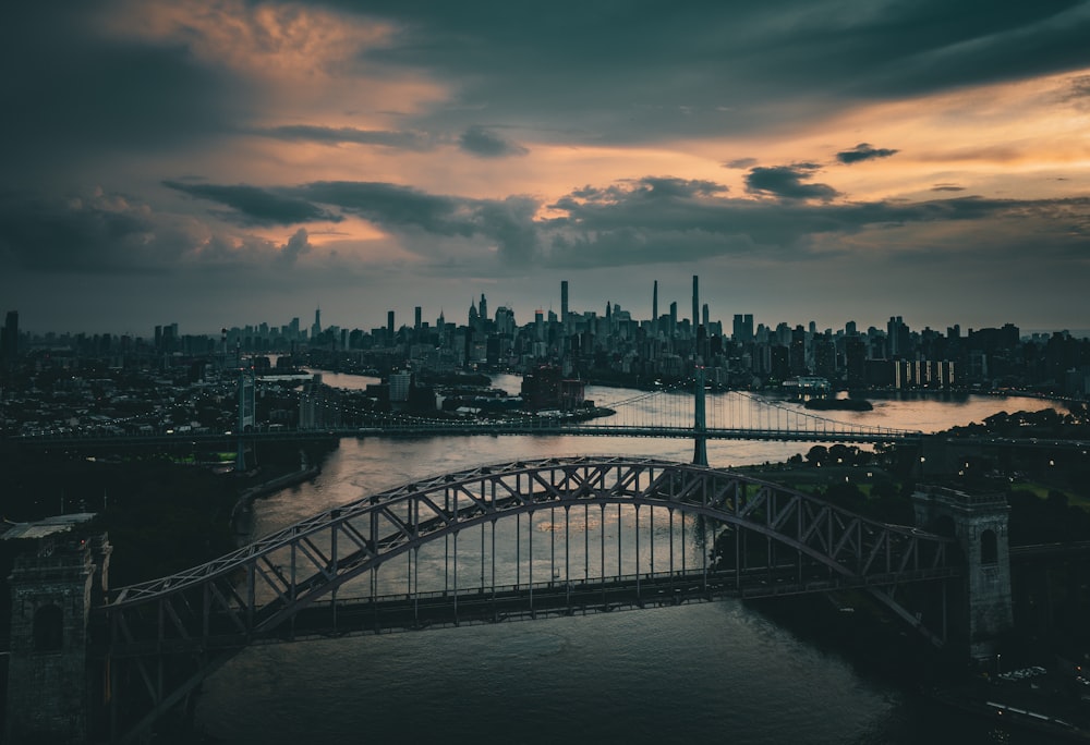 a bridge over a river with a city in the background