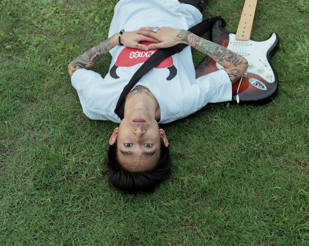 a person laying on the ground with a guitar