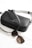 A sleek black leather handbag with a strap lies alongside a pair of tortoiseshell sunglasses. The handbag features the brand name 'Liebeskind Berlin' printed in white on the front.