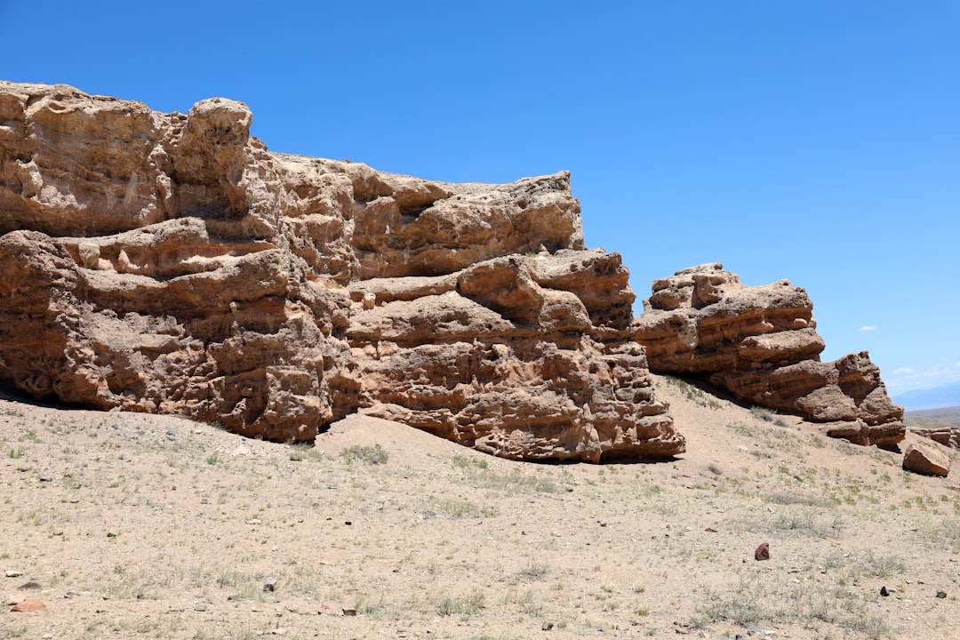 a large rock formation in the middle of a desert,