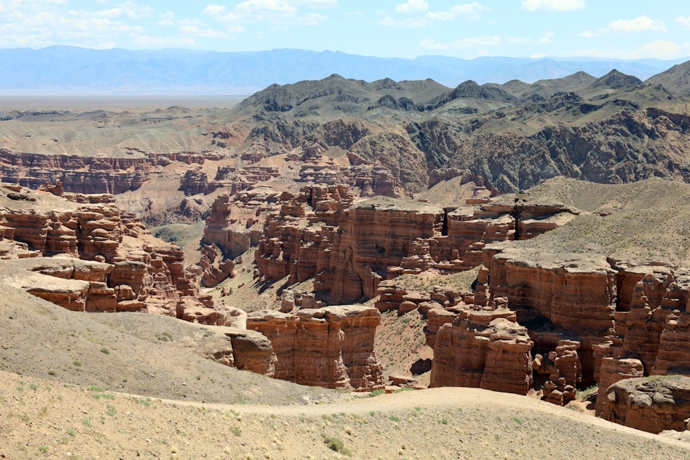 a view of a rocky landscape with mountains in the background