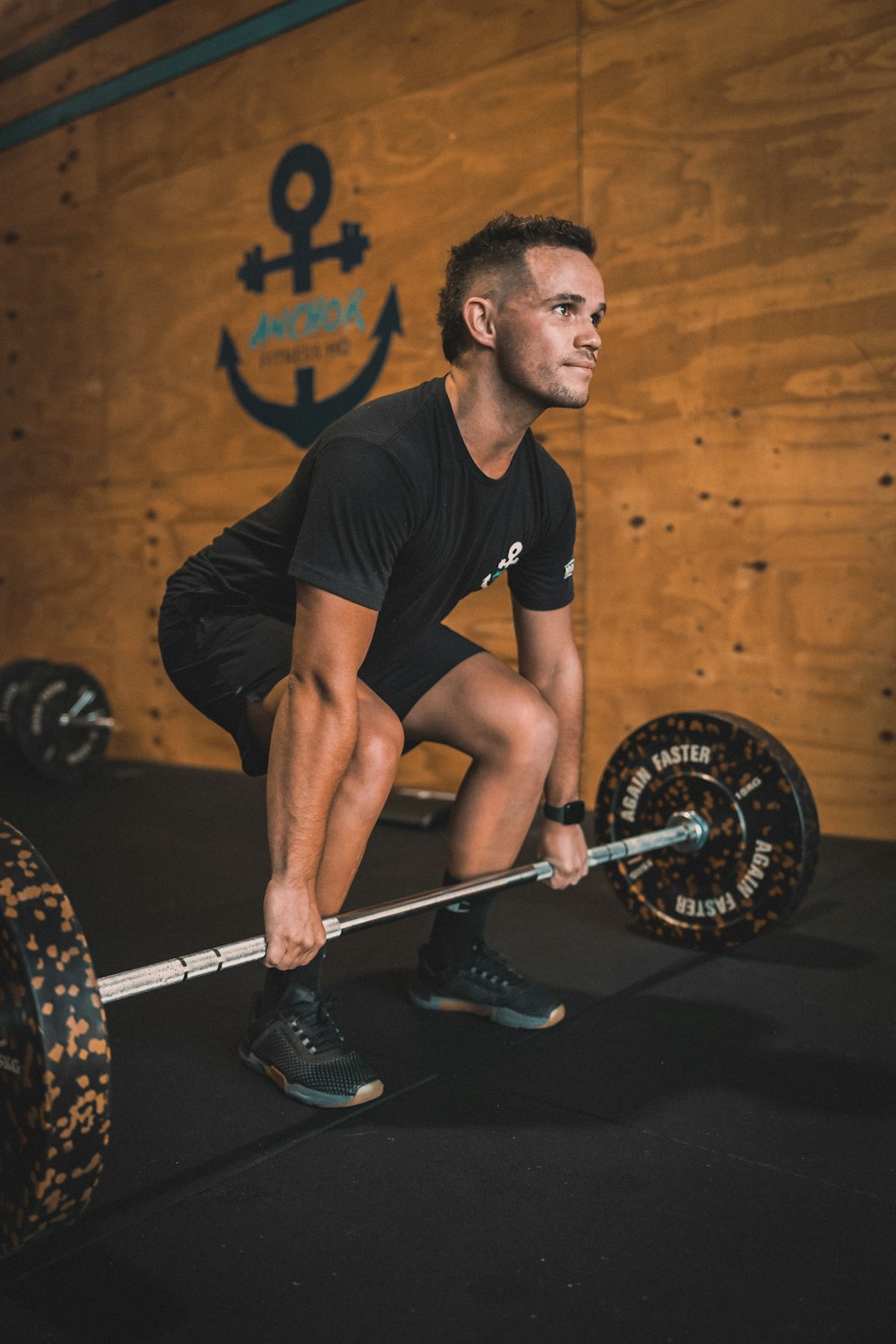 a man squats while holding a barbell