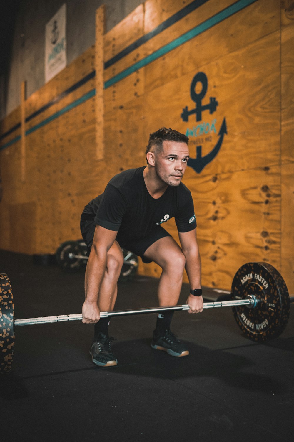 a man squatting on a barbell in a gym