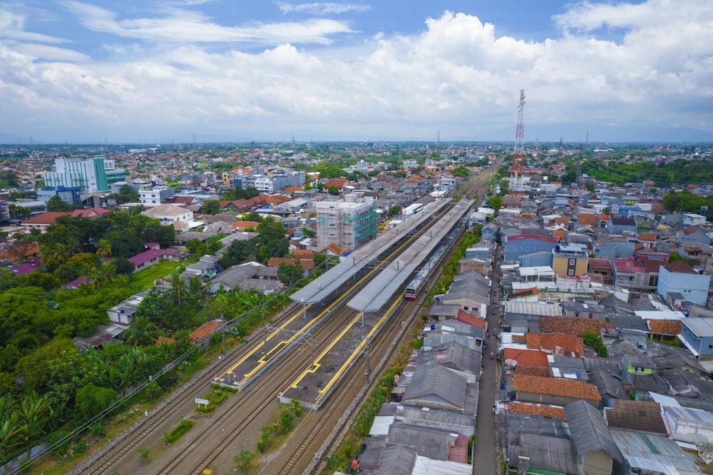 an aerial view of a city with a train on the tracks