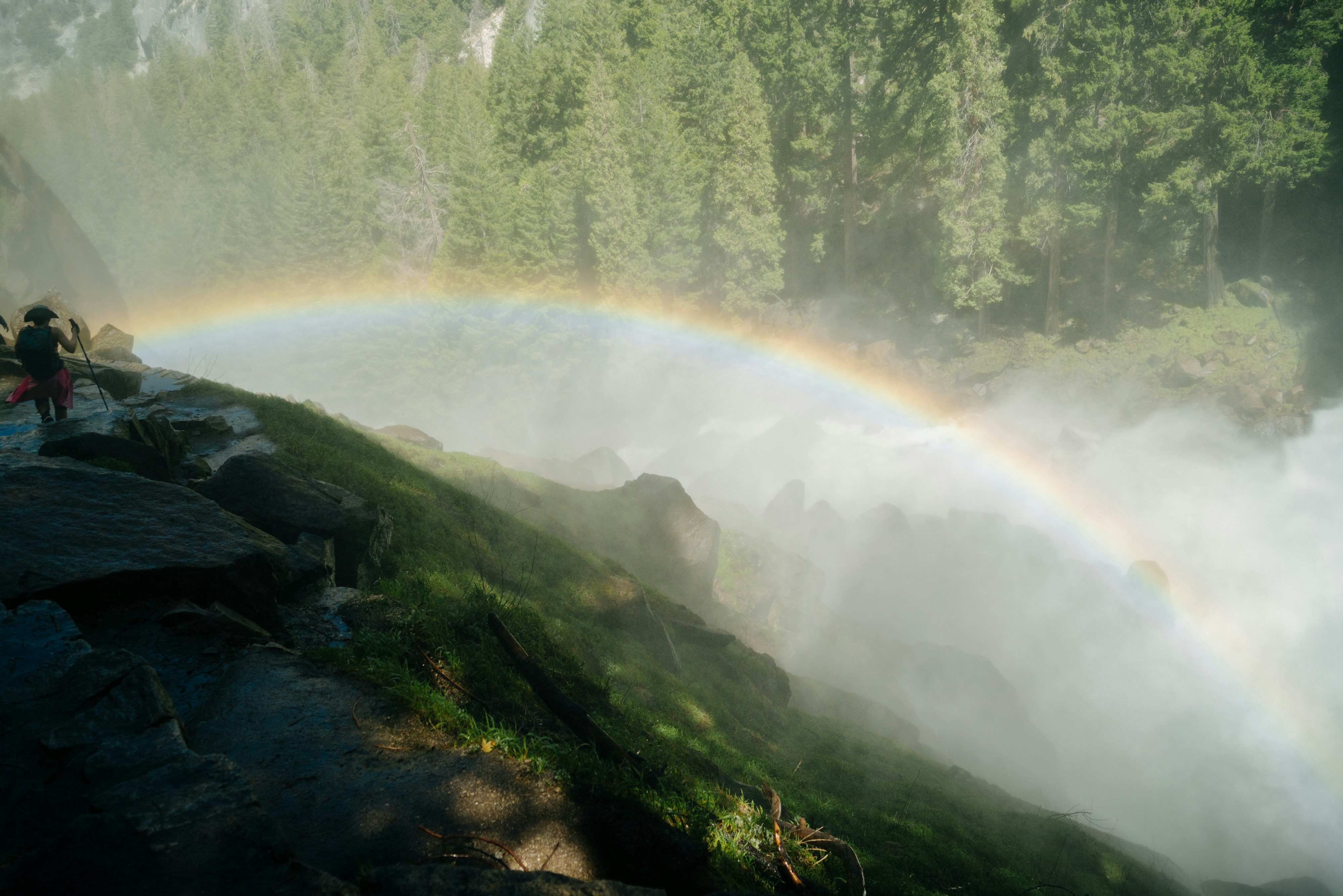 a rainbow in the sky over a waterfall, 