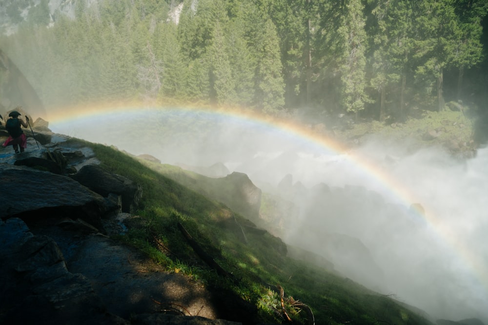 a rainbow in the sky over a waterfall