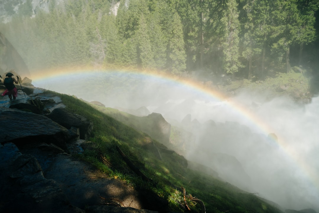 a rainbow in the sky over a waterfall,