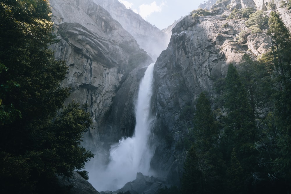 a very tall waterfall in the middle of a forest