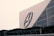 A large building with a modern architectural design features a prominent logo on its facade. The structure incorporates geometric patterns and metal elements, giving it an industrial look.